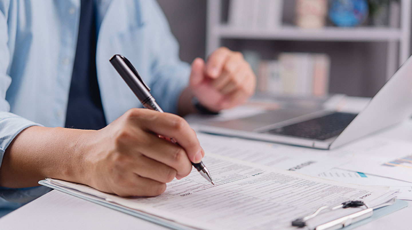 Vue de dessus d'une surface de travail organisée avec documents techniques et ordinateur pour la préparation d'un dossier de financement public